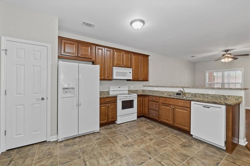150 Old Mill Road, Unit 435 Cartersville, GA 30120 - Photo 12 of 22 a large kitchen with stainless steel appliances granite countertop a stove a sink dishwasher and a refrigerator