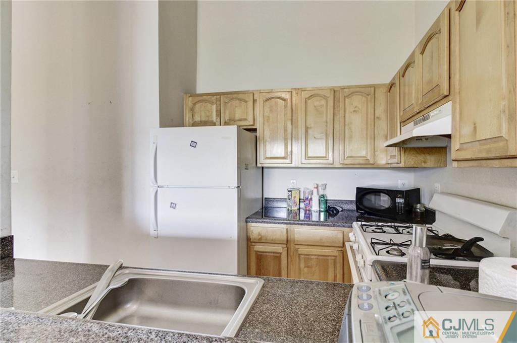 1131 Edpas Road, Unit 1131 New Brunswick, NJ 08901 - Photo 10 of 20 a kitchen with a sink a stove and cabinets