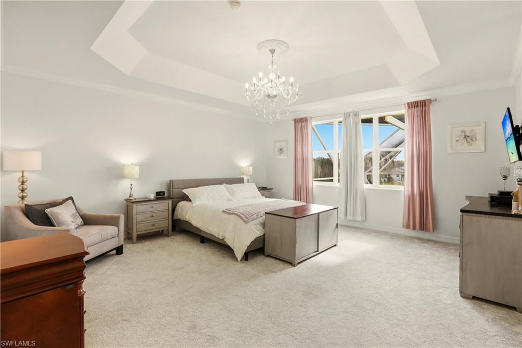 2150 Khasia Point Naples, FL 34119 - Photo 15 of 42 a spacious bedroom with a bed and a chandelier