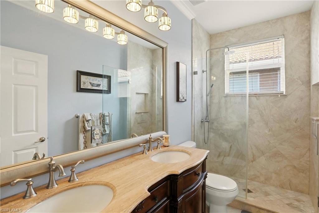 2150 Khasia Point Naples, FL 34119 - Photo 23 of 42 a bathroom with a granite countertop sink toilet a large mirror a shower and a tub