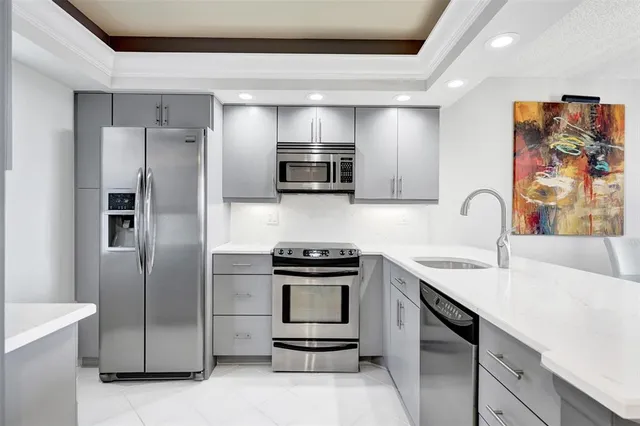 a kitchen with stainless steel appliances a stove a sink and a refrigerator