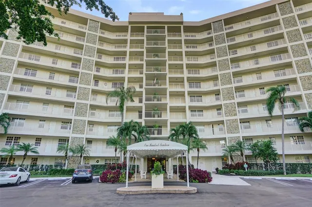 a front view of a building with a garden and plants