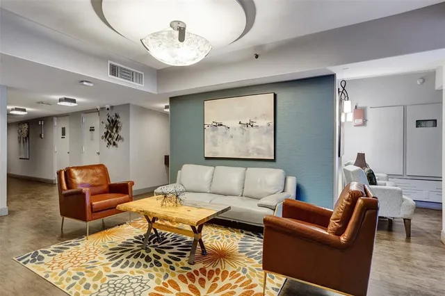a living room with furniture a rug and a chandelier