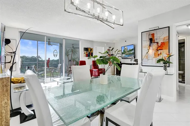 a view of a dining room and livingroom with furniture wooden floor chandelier