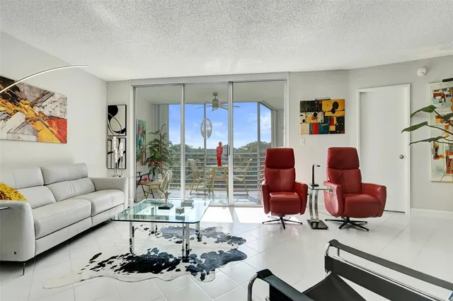 a living room with furniture and a floor to ceiling window