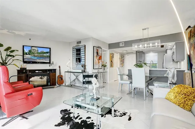 a living room with furniture a chandelier and a flat screen tv