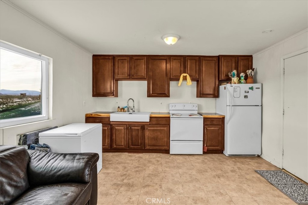 67550 Del Oro Road Twentynine Palms, CA 92277 - Photo 7 of 41 a kitchen with a refrigerator and a stove top oven