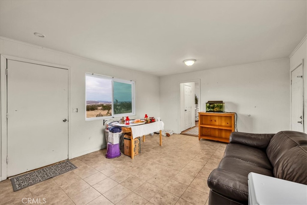 67550 Del Oro Road Twentynine Palms, CA 92277 - Photo 8 of 41 a living room with furniture a flat screen tv and a window