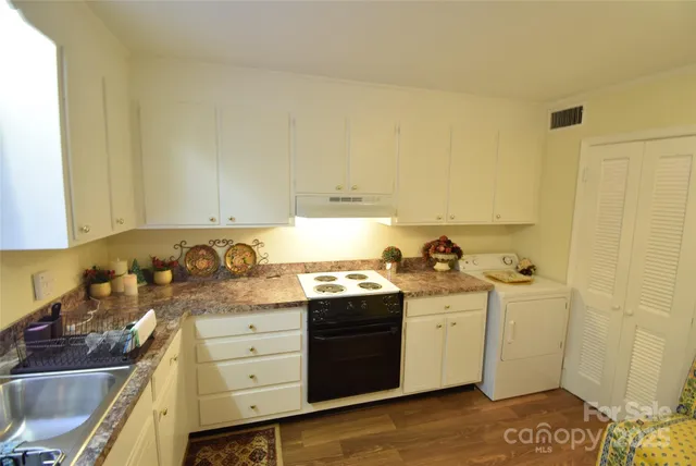 a kitchen with stainless steel appliances granite countertop a sink stove and cabinets