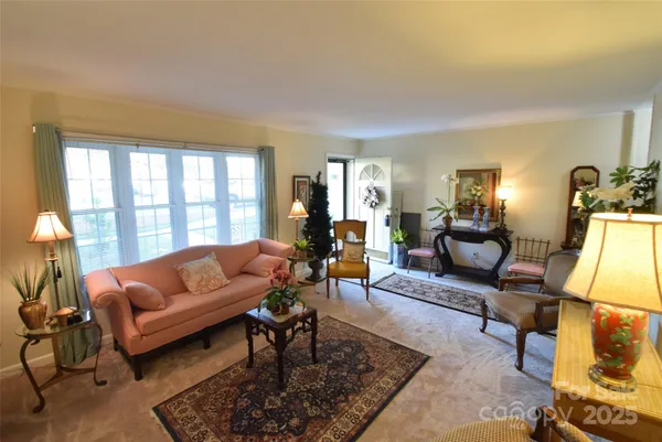 a living room with furniture a rug and a large window