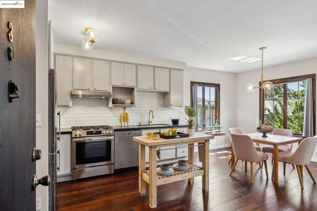 a kitchen with stainless steel appliances a stove a sink a stove a refrigerator cabinets and dining table