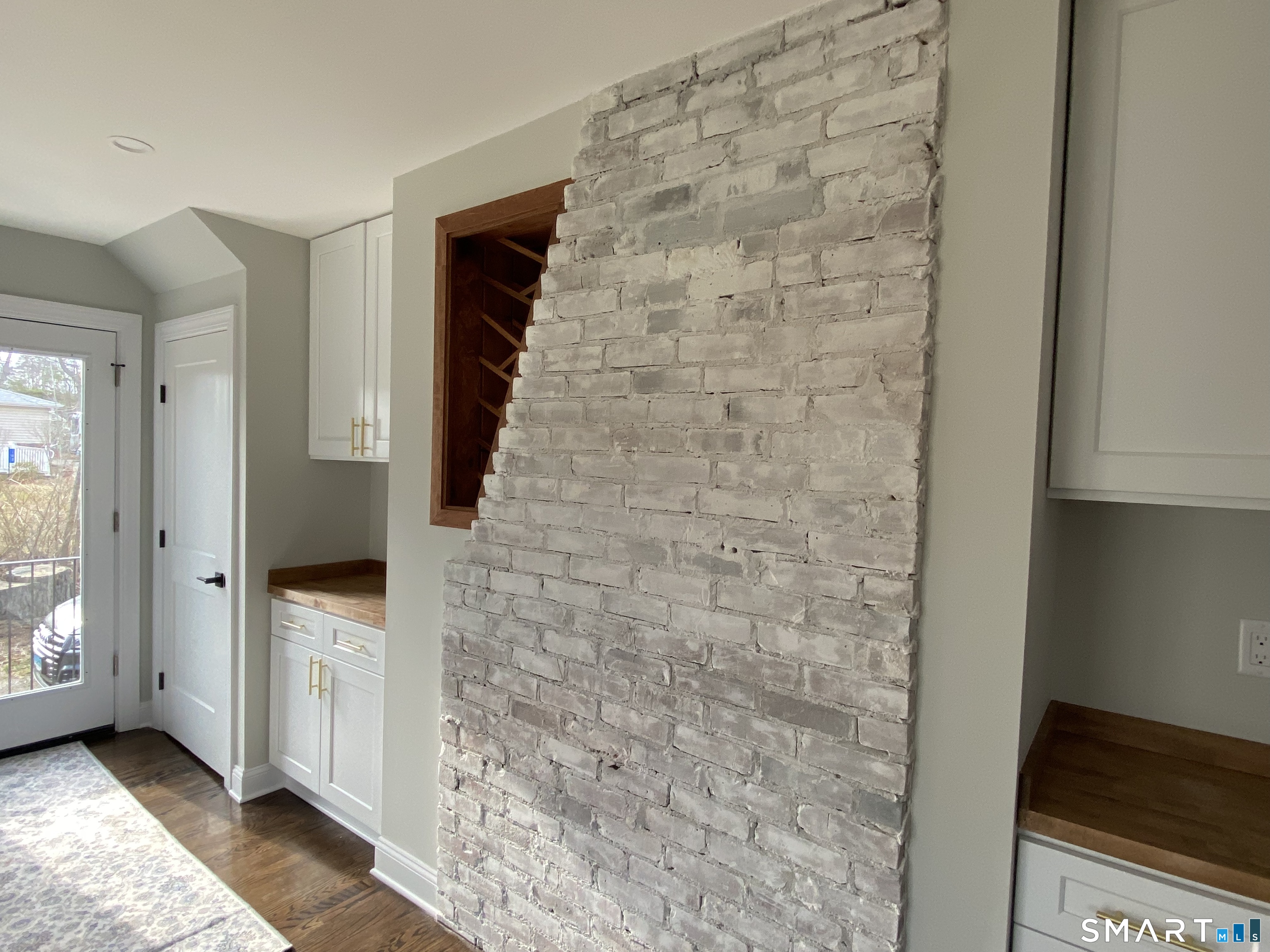 91 Prospect Street Watertown, CT 06795 - Photo 13 of 40 Exposed brick and wine rack and cabinets in kitchen.