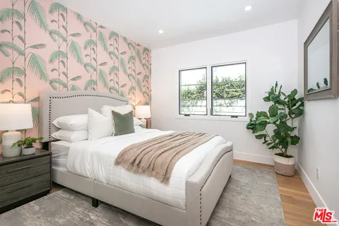 a bedroom with bed and a potted plant