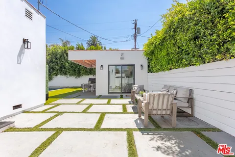 a view of a patio with table and chairs with wooden floor and fence