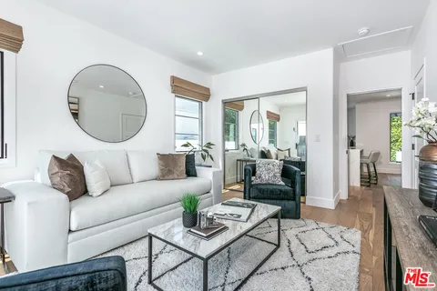 a living room with furniture and a mirror