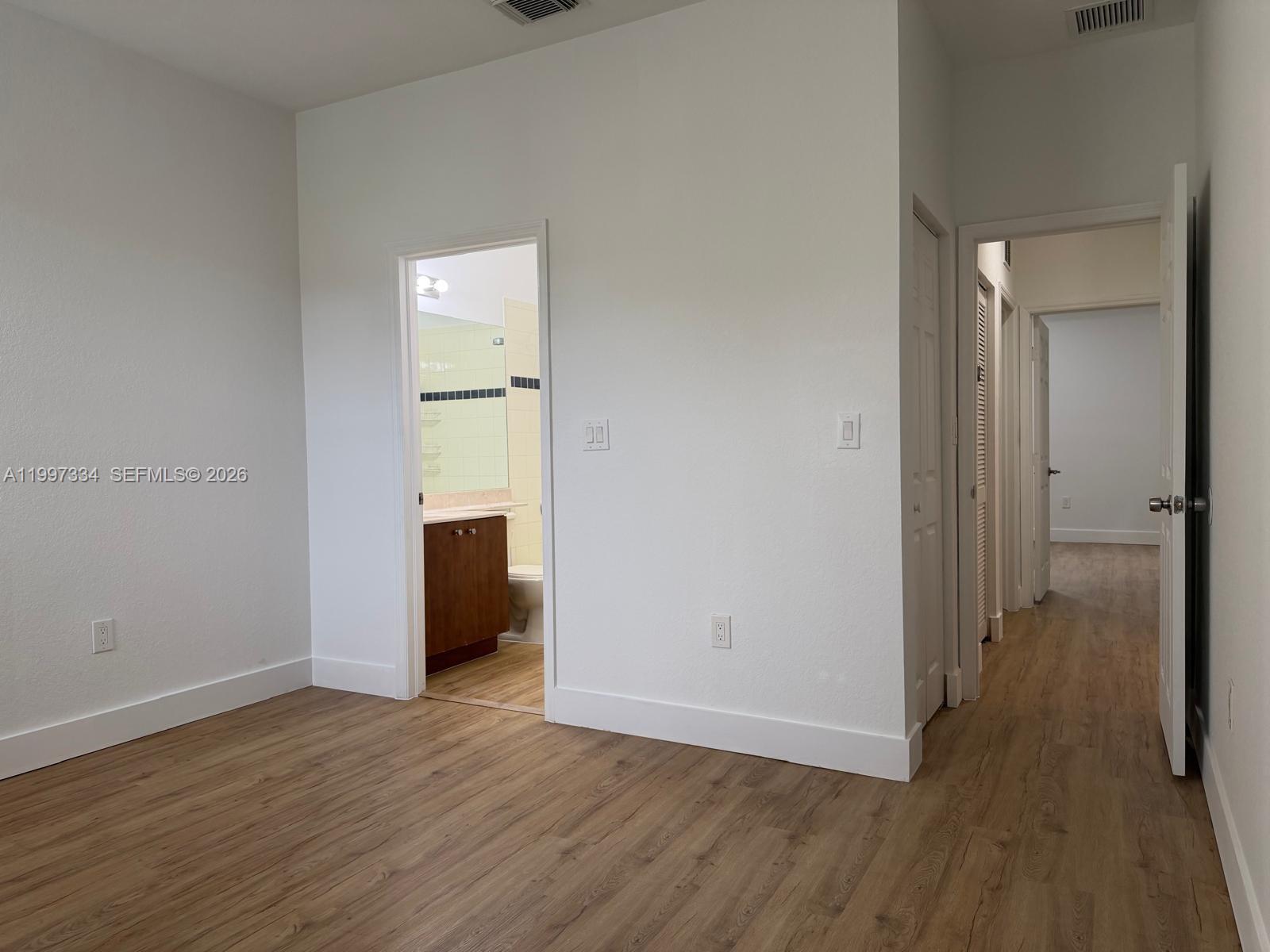 14934 Southwest 41st Lane, Unit 14934 Miami, FL 33185 - Photo 19 of 36 a view of a hallway with wooden floor and a bathroom