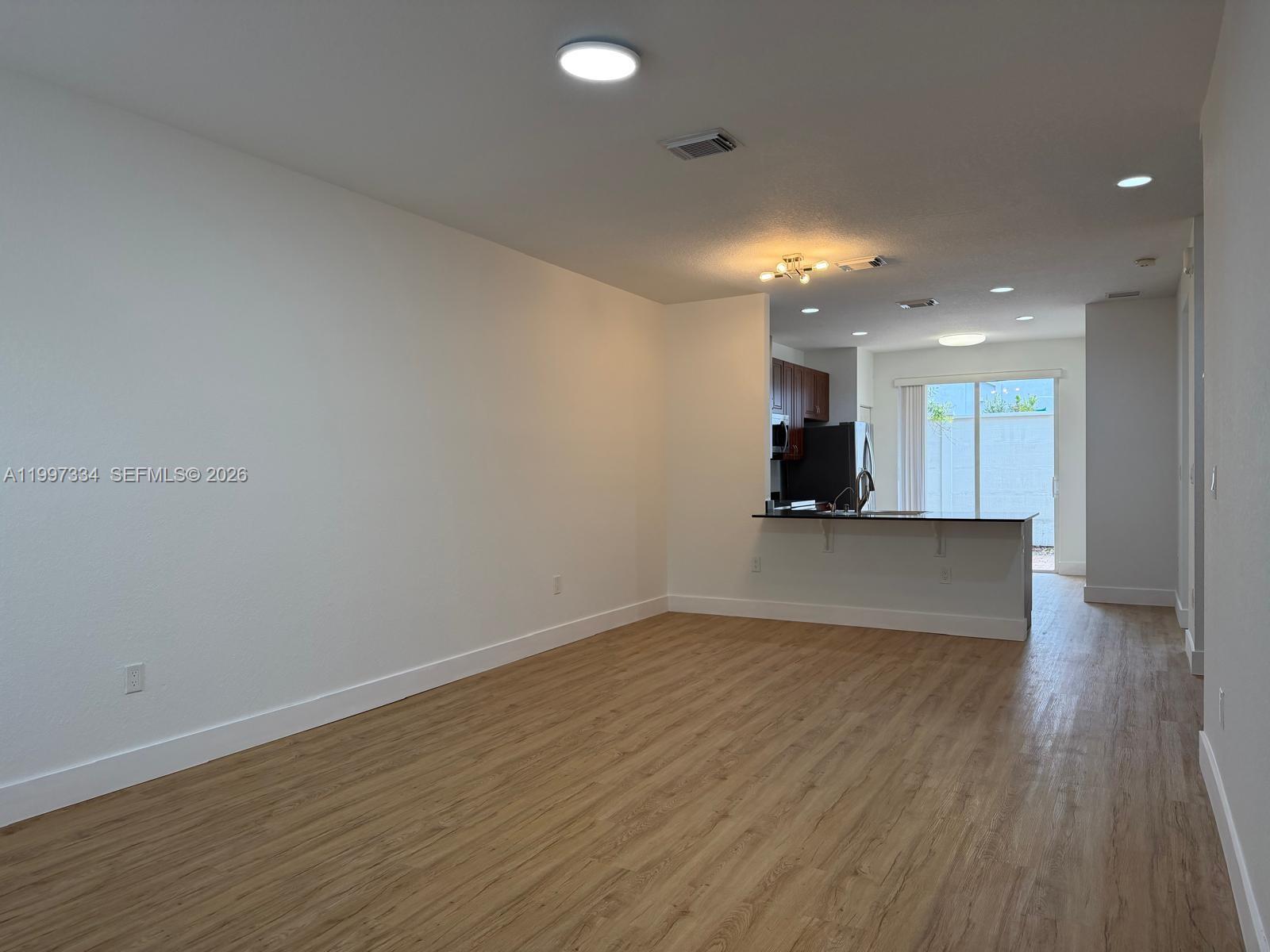 14934 Southwest 41st Lane, Unit 14934 Miami, FL 33185 - Photo 2 of 36 a view of a big room with wooden floor and windows