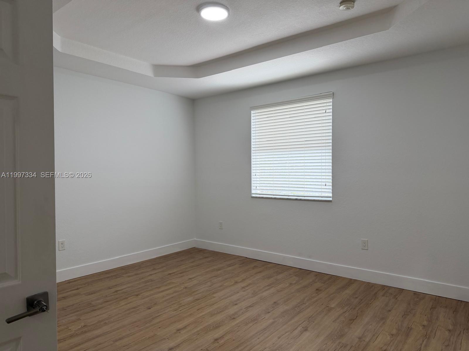 14934 Southwest 41st Lane, Unit 14934 Miami, FL 33185 - Photo 25 of 36 wooden floor in an empty room with a window