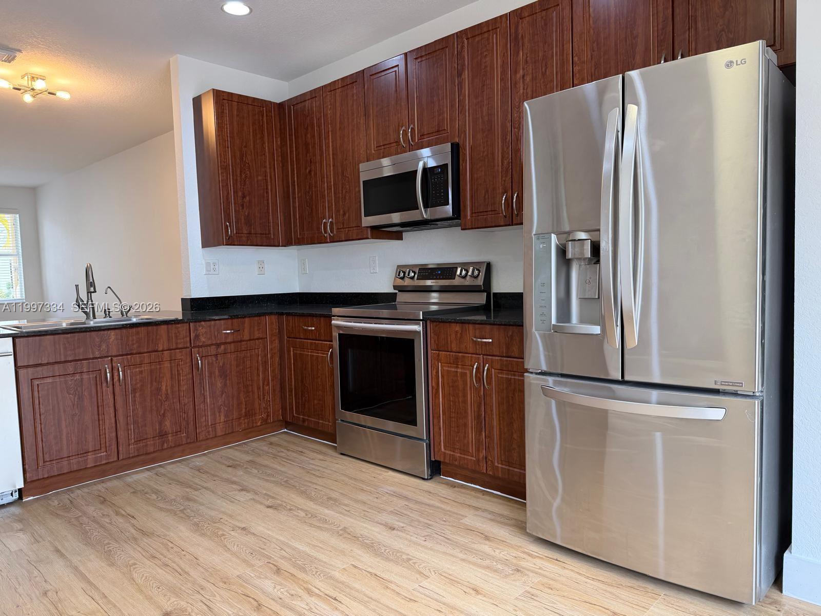 14934 Southwest 41st Lane, Unit 14934 Miami, FL 33185 - Photo 6 of 36 a kitchen with stainless steel appliances granite countertop a refrigerator stove and microwave