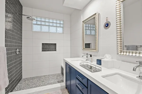 a bathroom with a double vanity sink and a mirror