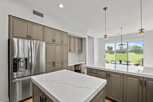 a kitchen with a refrigerator a sink and cabinets