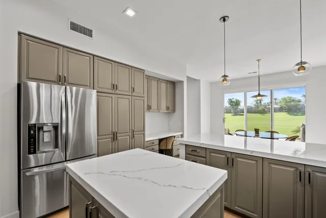a kitchen with a refrigerator a sink and cabinets