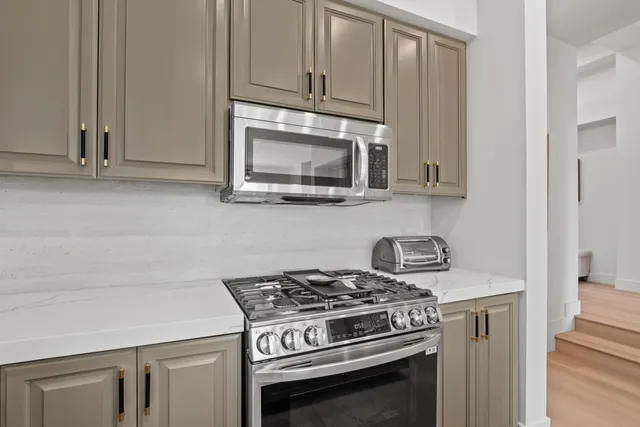 a stove top oven sitting inside of a kitchen