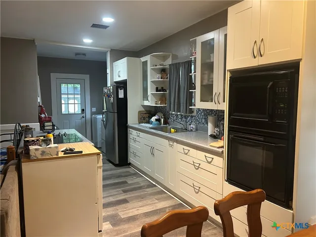 a kitchen that has a stove a sink and a refrigerator