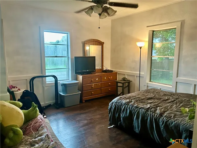 a bedroom with a bed and a dresser next to a window