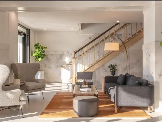 a living room with couches and a potted plant on a table