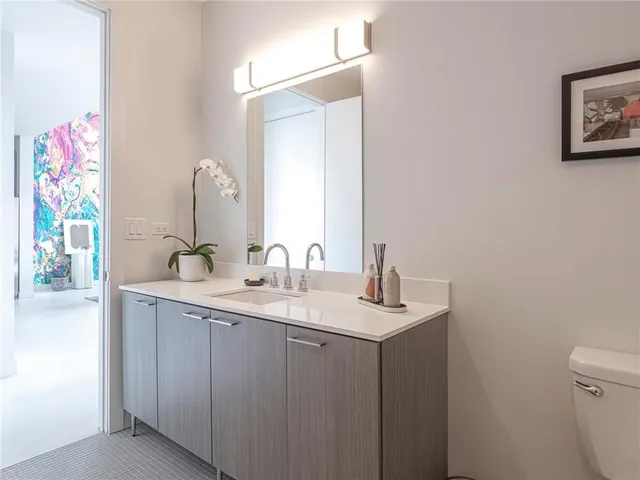 a bathroom with a granite countertop sink a toilet and a mirror
