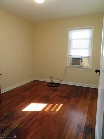 a room with a wooden floor and window