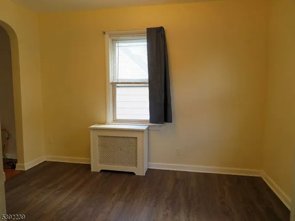 an empty room with wooden floor and a window