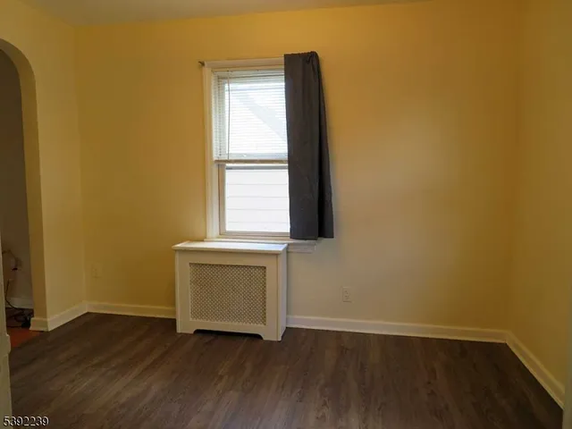 an empty room with wooden floor and a window
