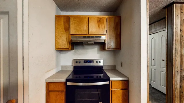 a kitchen with stainless steel appliances granite countertop white cabinets and a stove