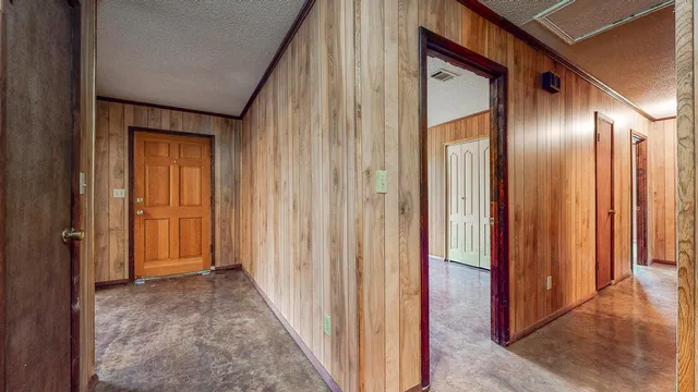 a view of a hallway with wooden floor and closet area