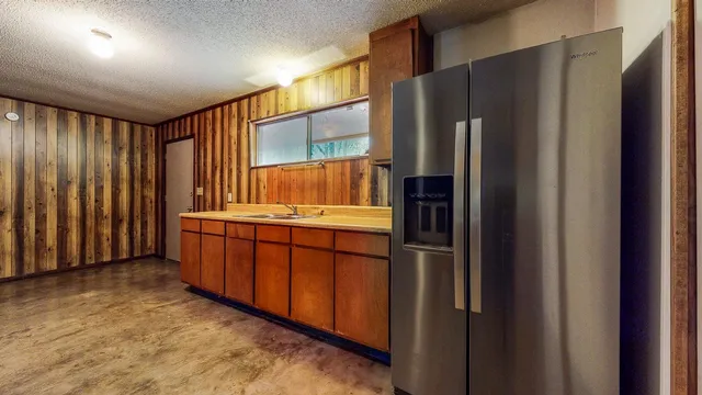 a kitchen with stainless steel appliances granite countertop a refrigerator and a sink