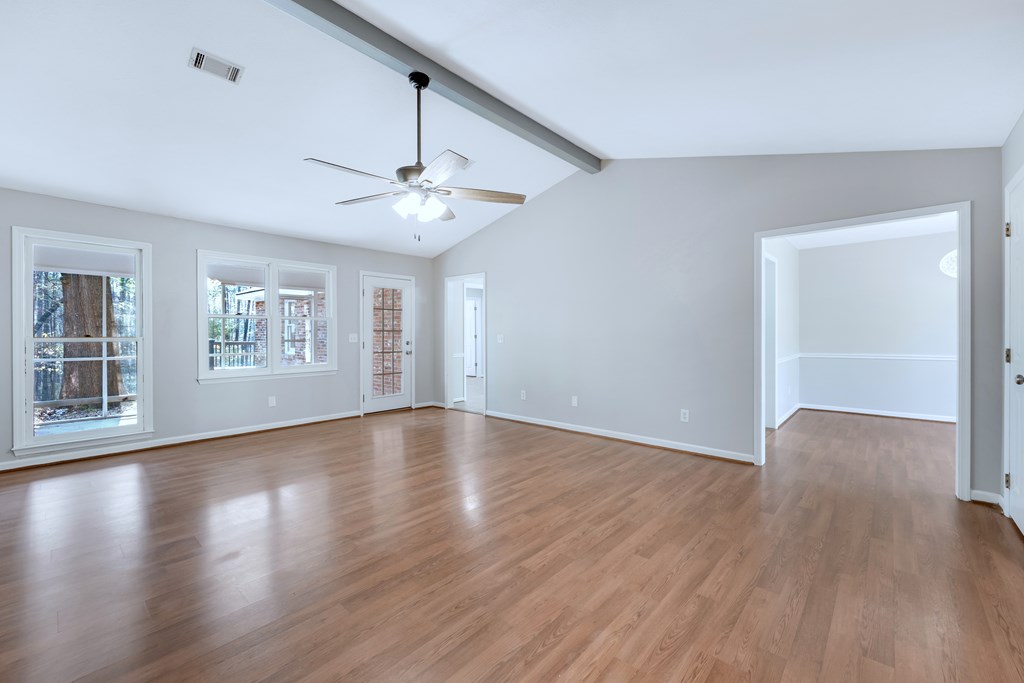 3330 Fortson Road Fortson, GA 31808 - Photo 20 of 46 an empty room with wooden floor chandelier fan and windows