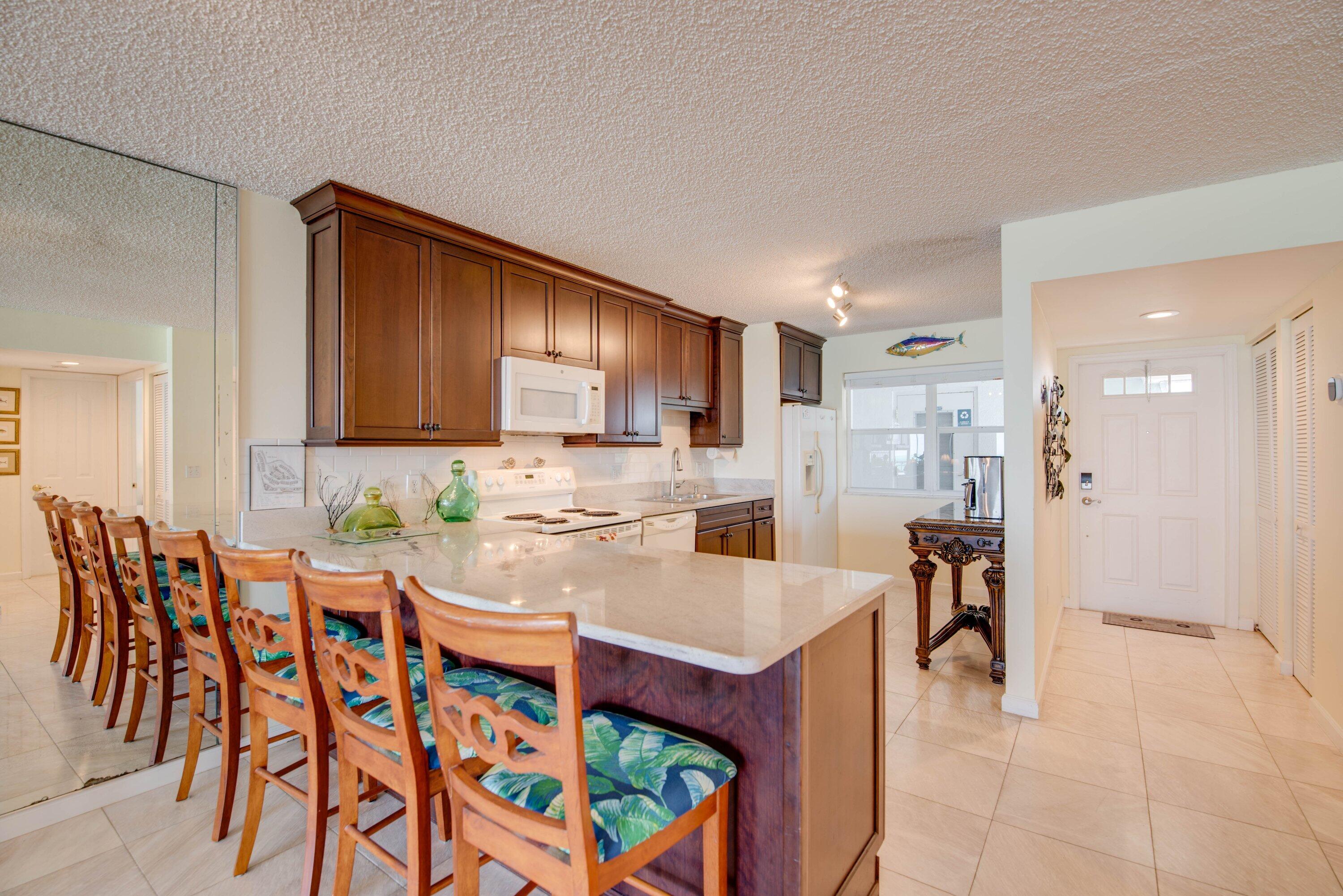 1901 South Roosevelt Boulevard, Unit 404S Key West, FL 33040 - Photo 11 of 39 a kitchen with stainless steel appliances kitchen island granite countertop a sink and cabinets