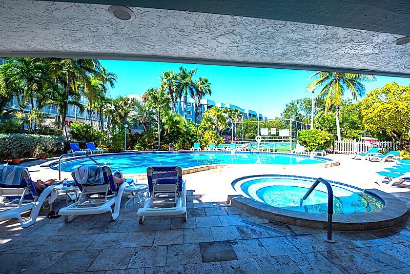 1901 South Roosevelt Boulevard, Unit 404S Key West, FL 33040 - Photo 24 of 39 a view of a swimming pool with lawn chairs under an umbrella