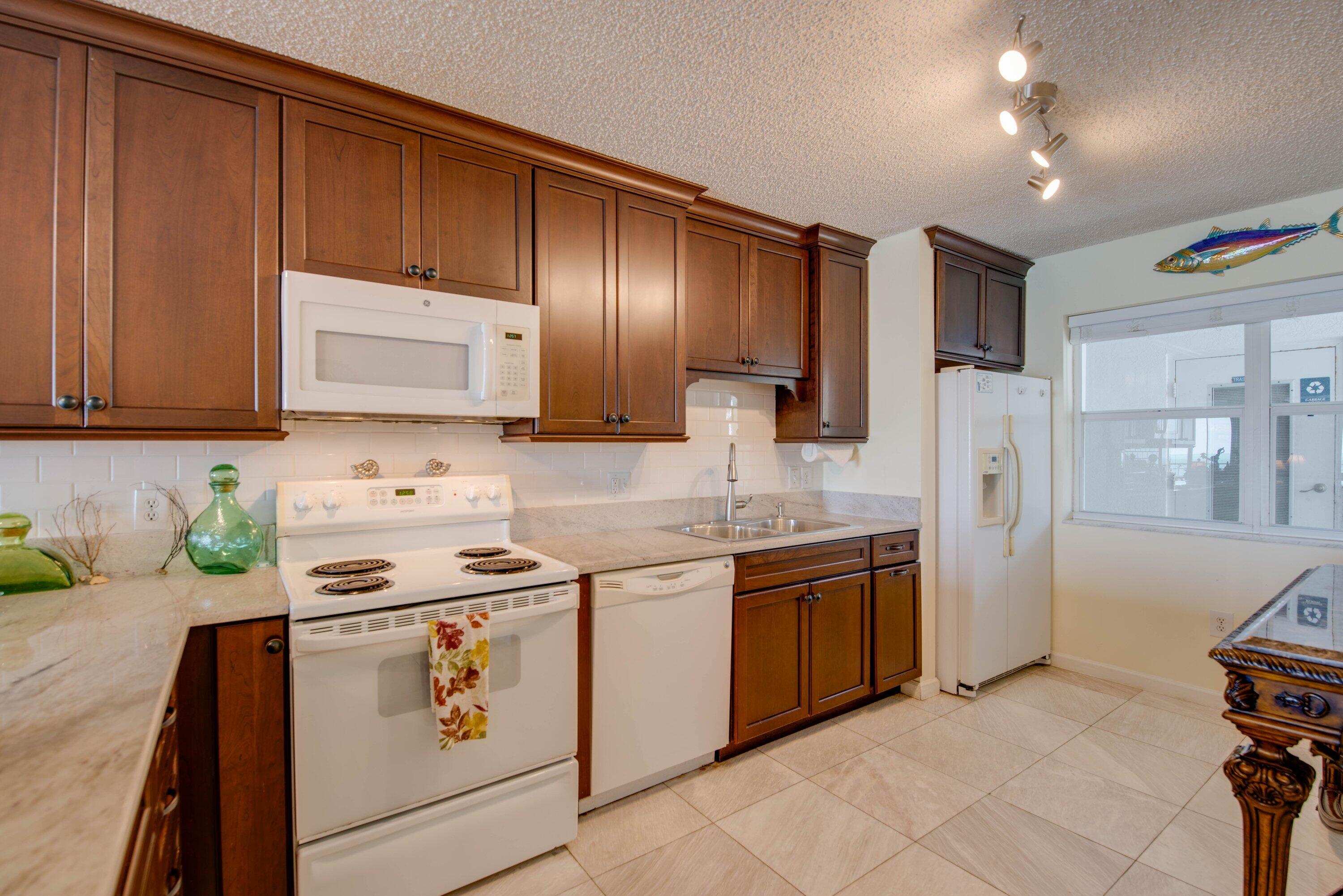 1901 South Roosevelt Boulevard, Unit 404S Key West, FL 33040 - Photo 10 of 39 a kitchen with stainless steel appliances granite countertop a stove a sink and a refrigerator