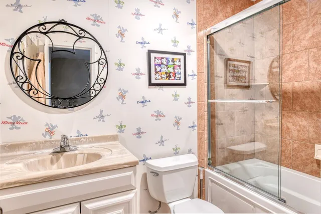 a bathroom with a sink a toilet and a mirror