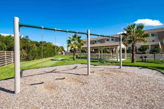a view of a house with a yard and palm trees