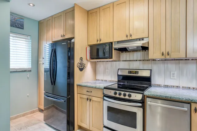 a kitchen with stainless steel appliances wooden cabinets and a stove top oven