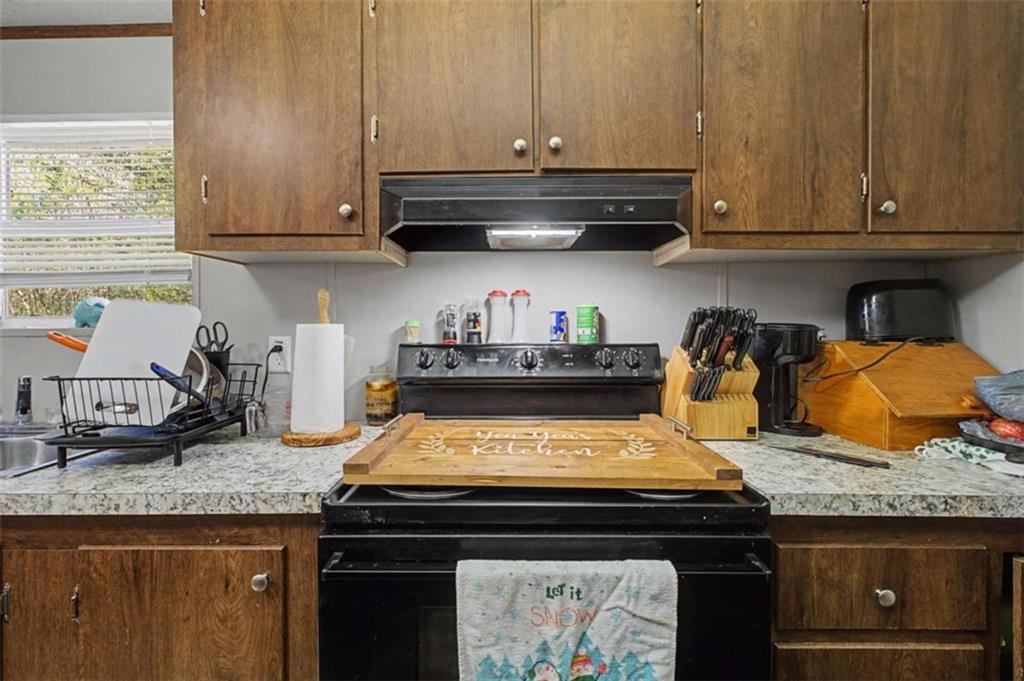 1343 Prior Station Road Cedartown, GA 30125 - Photo 12 of 39 a kitchen with granite countertop a stove a microwave and cabinets