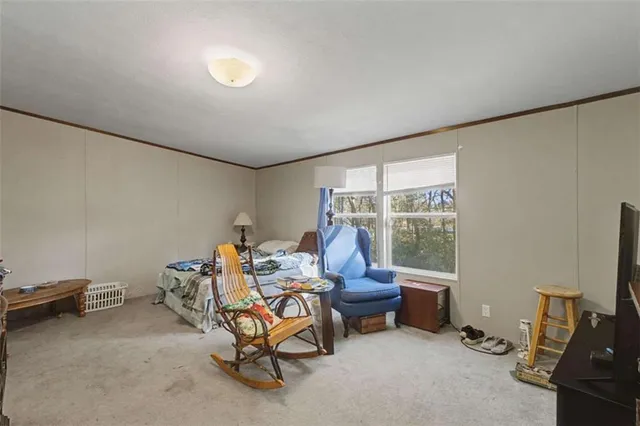 a living room with furniture a flat screen tv and a window