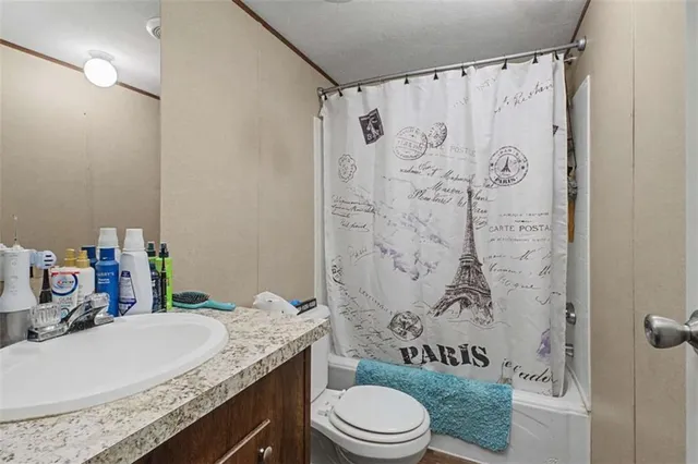a bathroom with a granite countertop sink toilet and shower