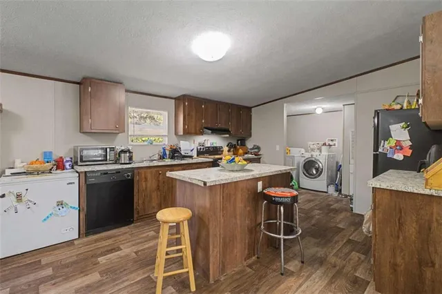 a kitchen with a table chairs refrigerator and microwave