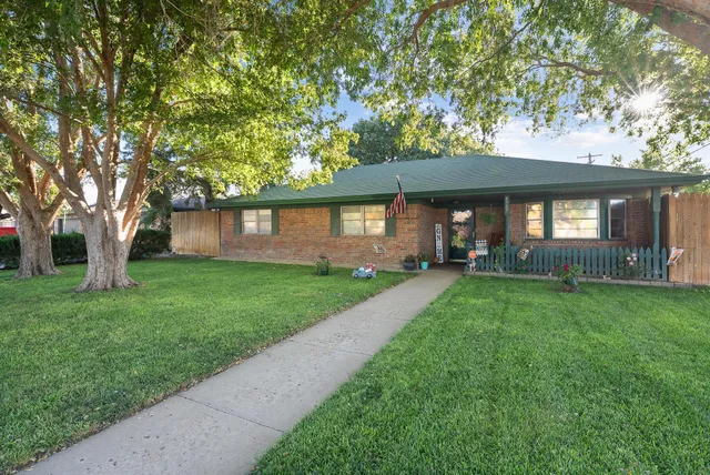 a front view of a house with a yard and garden