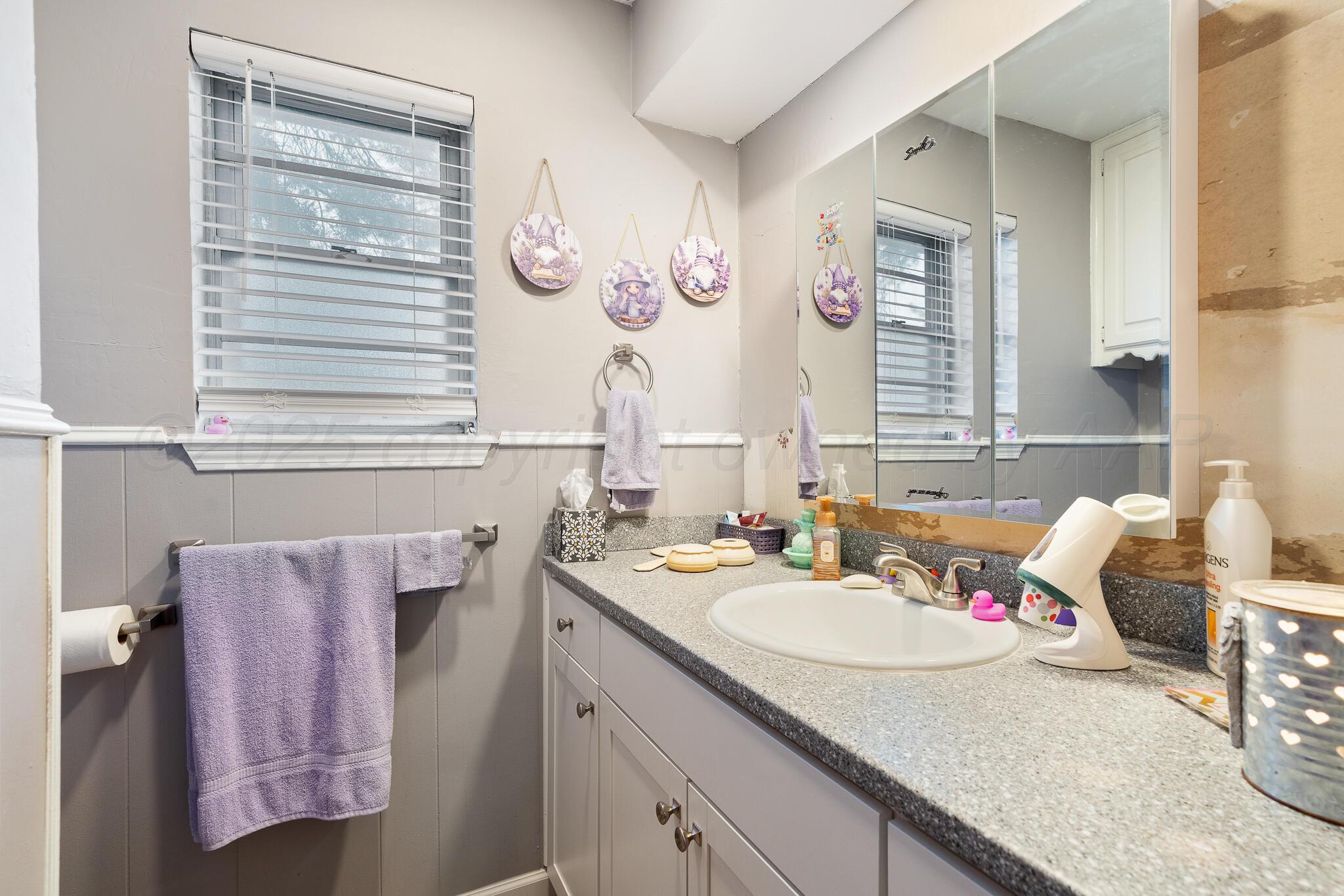 4307 Harmony Street Amarillo, TX 79109 - Photo 20 of 25 a bathroom with a granite countertop sink and a mirror